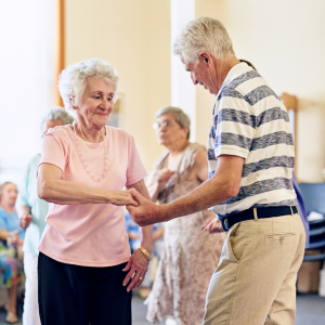 Two elderly people dancing together