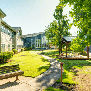 A cozy park with benches and a charming gazebo, nestled in front of a lovely apartment building.