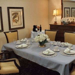 dining table set with napkins, plates and flowers in the middle