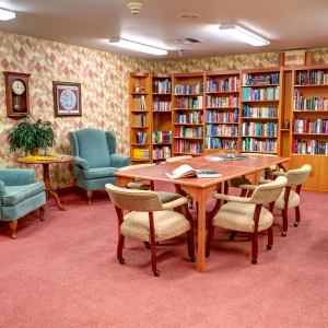 library with a large table, chairs and lots of bookshelves