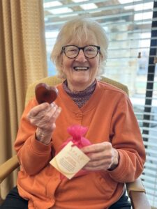 elderly woman holding up a heart shaped bar of soap