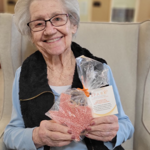 elderly lady holding a bag of crafts