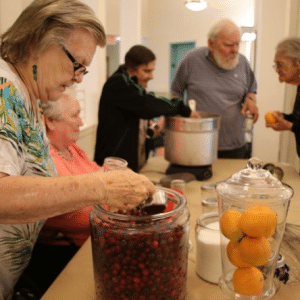 elderly people filling jars with jam