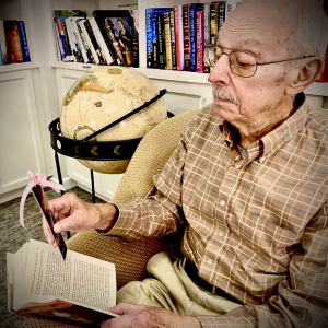 elderly man reading a book with a book mark