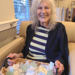 elderly woman holding basket of soaps in bags