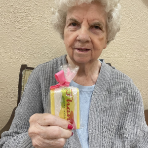 elderly woman holding a box of candy
