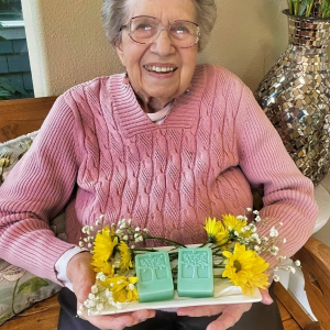 elderly woman holding tray with 2 bars of soap
