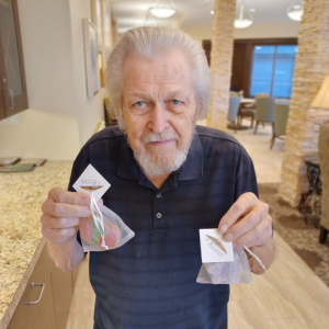A kind older gentleman proudly displays two bags of handmade soap