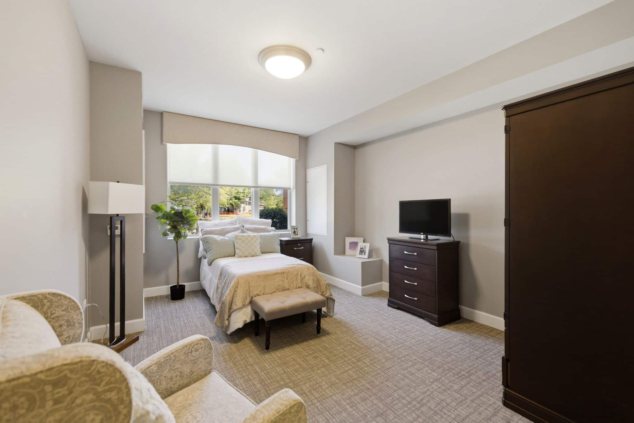 A beautiful large bedroom with a window behind the bed.