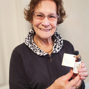 elderly woman holding a bottle of vanilla extract