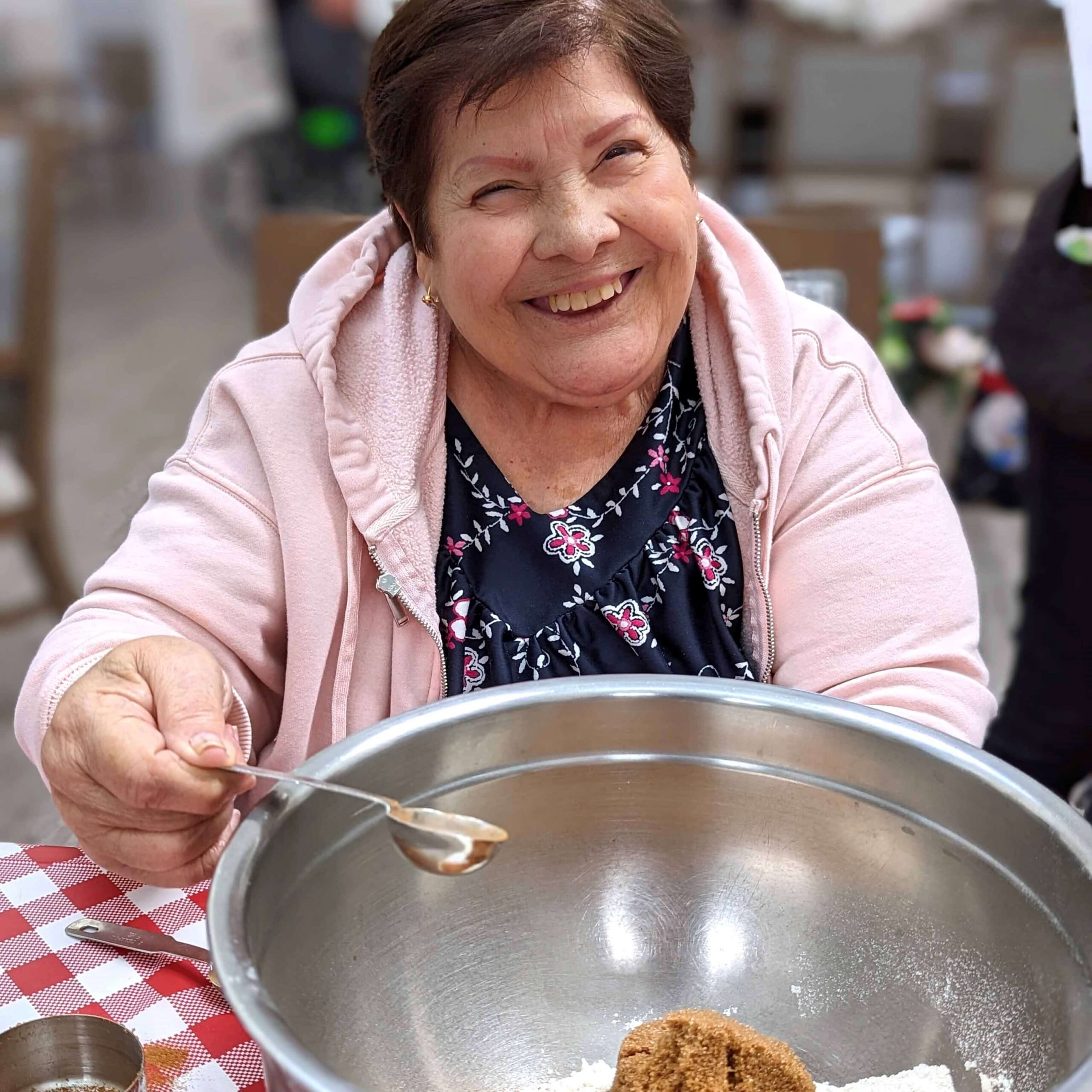 Elderly woman mixing baking ingredients.