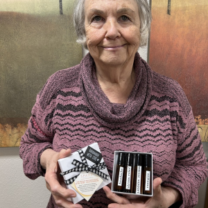elderly lady holding a box of oils