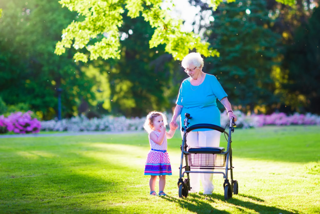 Grandmother using walker and walking with granddaughter