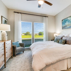 A cozy bedroom with a comfy bed, a stylish dresser, and a ceiling fan to keep you cool.