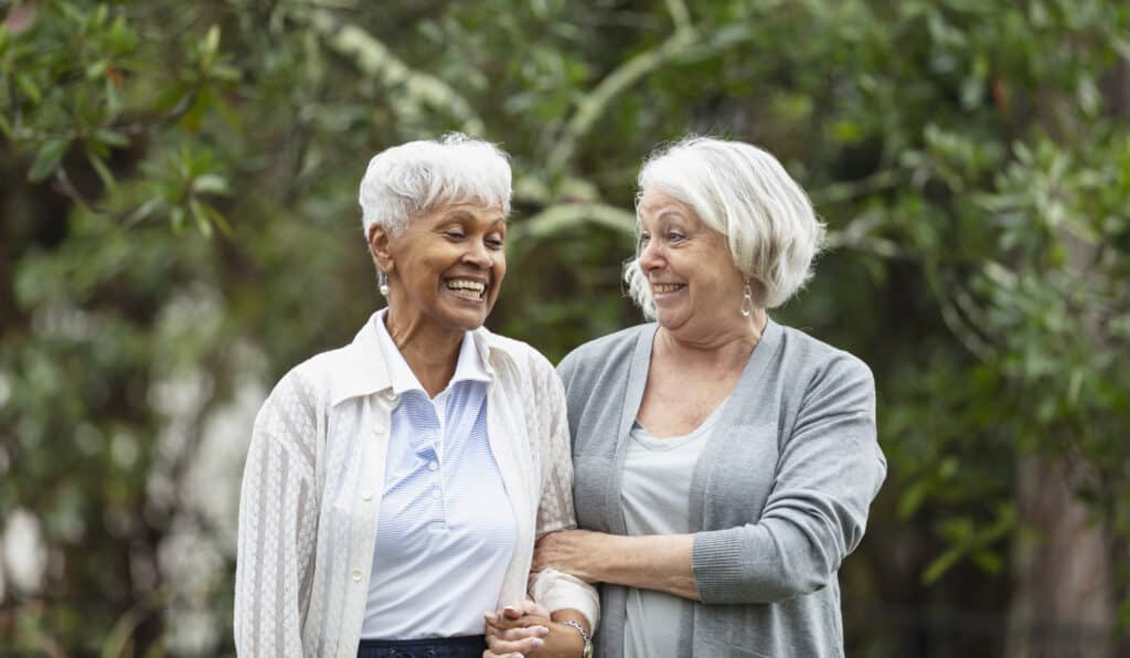 Two elderly people walking and smiling