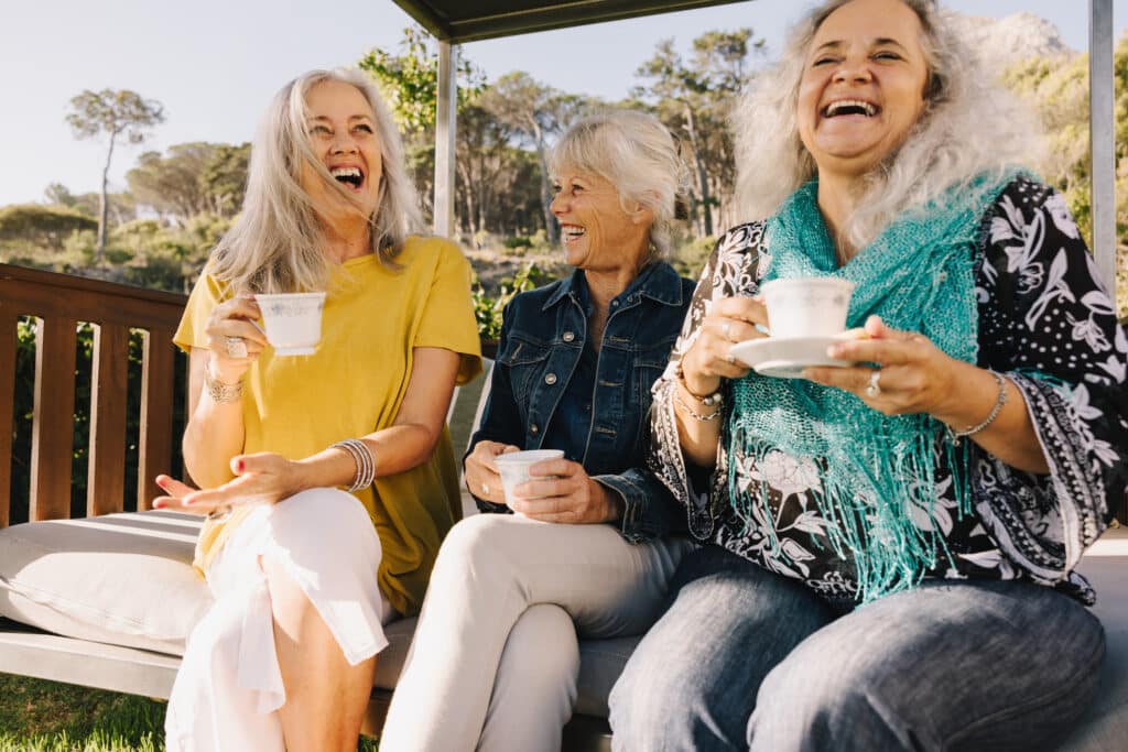 Friends laughing happily while having tea