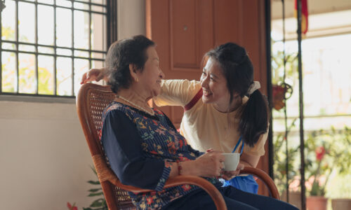 senior woman at home being visited by her granddaughter