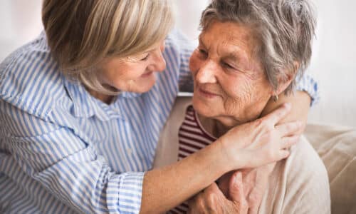 Two senior women at home, hugging. Family and generations concept.