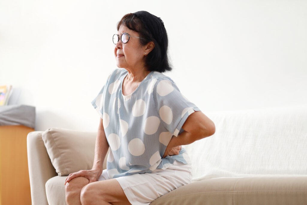 Portrait of Elderly Asian Woman Having Back Pain in the Living Room