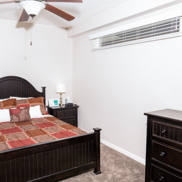 Bed inside a bedroom with a ceiling fan