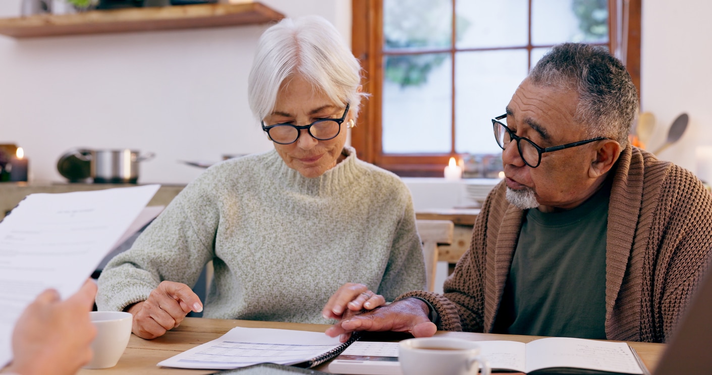 Couple, paperwork and reading for insurance in retirement