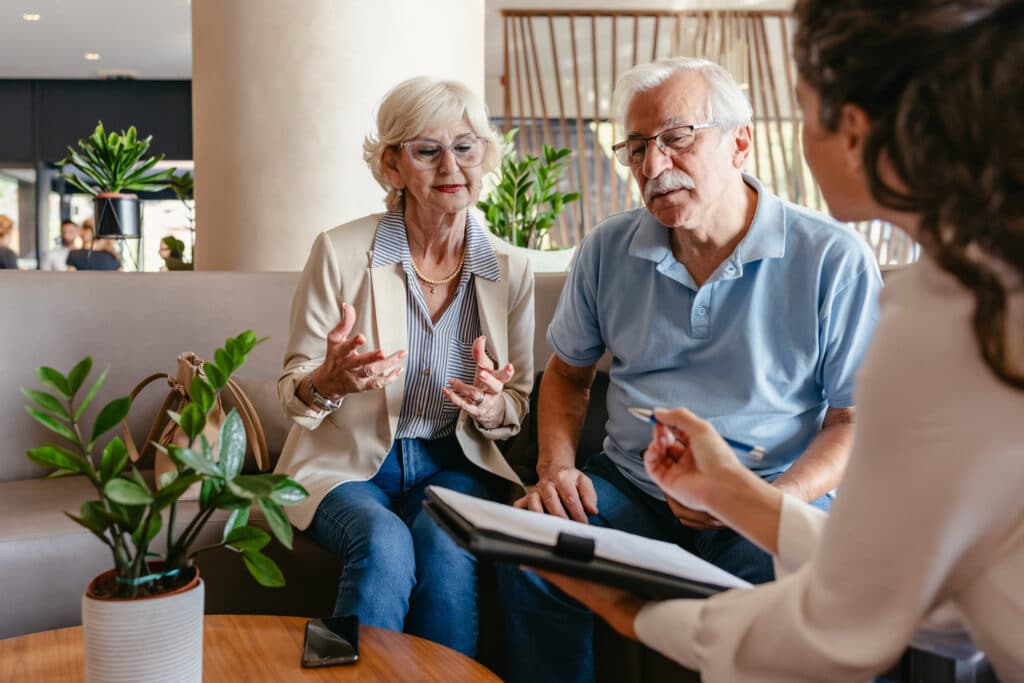 An elderly couple sits and chats