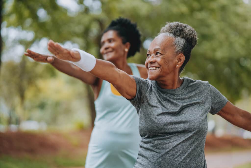 Two women friends doing exercises together senior and mature

