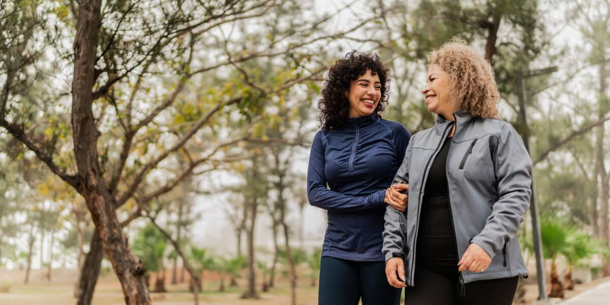 Mother and daughter talking while walking through the public park